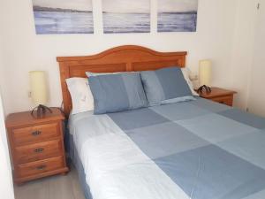 a bedroom with a bed with blue sheets and two night stands at Hervas Centro Apartamento IDEAL FAMILIAS 6 adultos y 2 niños- in Hervás