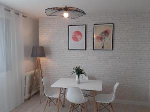 une salle à manger avec une table blanche et des chaises blanches dans l'établissement Un appartement lumineux avec vue exceptionnelle avec 3 chambres, à Bourg-lès-Valence