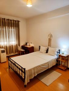a bedroom with a large bed and a desk at Flor da Providência in Viseu