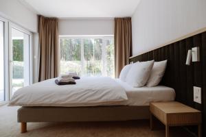 a bedroom with a large bed with a large window at Sea Shell Apartments Łukęcin in Łukęcin