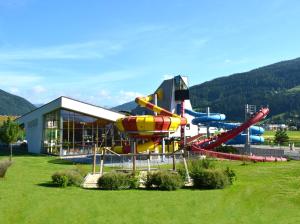 a water park with a water slide in a field at Apartmenthaus Kuchelberg in Altenmarkt im Pongau