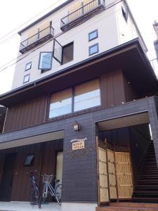 a building with two bikes parked outside of it at Guesthouse WIND VILLA Kyoto in Kyoto