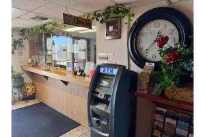 an atm machine in a store with a clock on the wall at Travelers Inn by Hotel O Lake Havasu City in Lake Havasu City