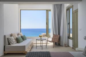 a living room with a couch and a view of the ocean at Panorama in Myrtos