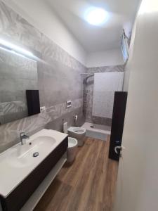 a bathroom with a white sink and a toilet at Villetta Sanlea in Lecce +2 photos