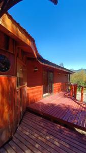 a large wooden deck next to a house at Aguas Sagradas de Panqui in Curarrehue