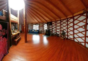 a large room with a wooden floor in a yurt at Aguas Sagradas de Panqui in Curarrehue