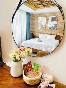 a bedroom with a bed and a mirror on the wall at 204MSNK Maison Luxe Studio w Big Window & Kitchen in Can Tho