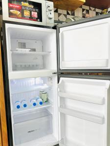 an empty refrigerator with its door open in a kitchen at 204MSNK Maison Luxe Studio w Big Window & Kitchen in Can Tho