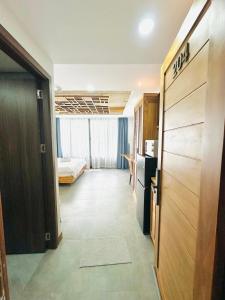 a hotel room with a bed and a hallway at 204MSNK Maison Luxe Studio w Big Window & Kitchen in Can Tho