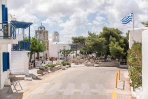 a street in a town with a flag on the road at kefos apartments paros in Kóstos