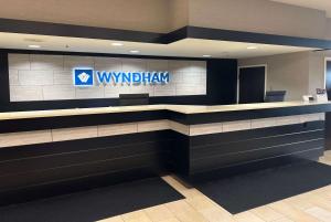 a view of a lobby with a vmhealth sign on the wall at Wyndham Minneapolis South Burnsville in Burnsville