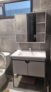 un bagno con lavandino, specchio e WC di Nexus Lodge a Abidjan