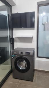 una lavatrice con una TV sopra di Nexus Lodge a Abidjan