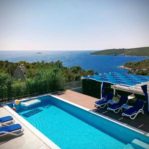 una piscina con sillas y vistas al océano en LUXURY VILLA ŠENTADA, en Vinišće