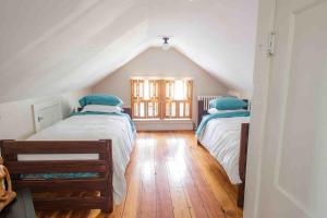 a attic bedroom with two beds and a window at The Wildflower House Yellow Springs AND Pet Friendly 
