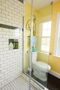a bathroom with a toilet and a glass shower at The Wildflower House Yellow Springs AND Pet Friendly 