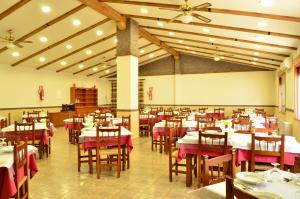 a dining room with tables and chairs with red tablecloths at Hotel-Balneario La Esperanza in Reolid