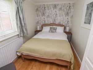 a bedroom with a bed in a room with a window at Rose Briar Cottage in Morpeth
