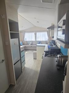 a kitchen and living room with a couch and a stove at Caravan to Hire - CalaGran Fleetwood Blackpool in Fleetwood