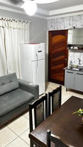 a kitchen and living room with a couch and a refrigerator at 10 MIN AEROPORTO GUARULHOS in Guarulhos +43 photos