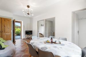 un salon blanc avec une table et des chaises dans l'établissement La Maison de Noélie - RDJ, à Le Bar-sur-Loup