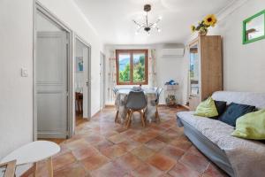 un salon avec une table et un canapé dans l'établissement La Maison de Noélie - RDJ, à Le Bar-sur-Loup