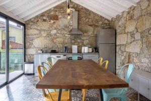 Una cocina con una mesa y sillas de madera. en Casa do Mestre Studio e Suíte Extra, en Vila de Punhe