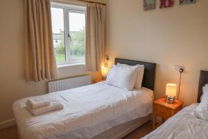 een kleine slaapkamer met twee bedden en een raam bij The Picnic Patch at Eamont Park in Penrith +24 foto's