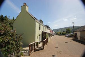 a green and white building on a street at Eilean Donan View in Dornie