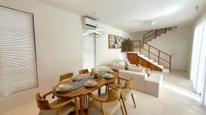 Un comedor con una mesa y sillas y un sofá. en Bali Ocean Uluwatu Retreat 2Fls Gold, en Uluwatu