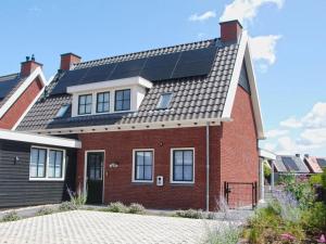 a house with solar panels on the roof at Coast Calm 71 in Colijnsplaat