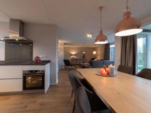 a kitchen and dining room with a long table and chairs at Coast Calm 71 in Colijnsplaat