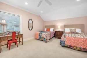 Un dormitorio con dos camas y un escritorio y un espejo. en 607 Neptune Way, en Saint Simons Island 33 fotos más