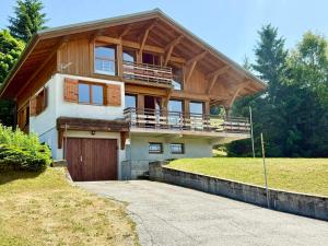 une grande maison avec un toit en bois et un garage dans l'établissement Chalet de charme avec sauna et vue sur les montagnes - FR-1-505-181, à Crest-Voland