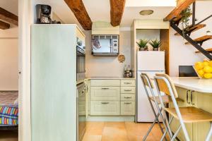 a kitchen with a white refrigerator and a table and chairs at Fridays Flats Dreamy Duplex - Stylish Beach Loft in Barcelona