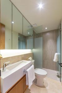 a bathroom with a sink and a toilet and a mirror at Departamento con vista lateral al mar en Zantamar in Cruz de Huanacaxtle