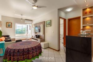 eine Küche und ein Wohnzimmer mit einem Tisch im Zimmer in der Unterkunft Condomínio bem localizado a 100m da Praia - CSC in Florianópolis