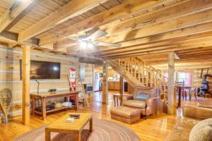 a living room with a ceiling fan and wooden walls at Bear In Flannel Cabin Hot Tub in Townsend
