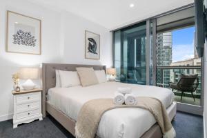 a bedroom with a bed with two towels on it at Elegant High-End CBD Suite Heated Pool Gym Sauna in Melbourne +40 photos