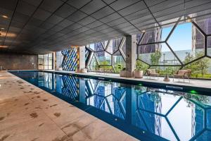 a swimming pool with a view of a building at Elegant High-End CBD Suite Heated Pool Gym Sauna in Melbourne