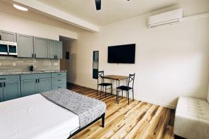 a bedroom with a bed and a kitchen with a table at Unit 4 Waena Inn Newly Renovated Maui Private Suite in Wailuku