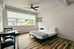 a bedroom with a bed and a desk and a window at Unit 4 Waena Inn Newly Renovated Maui Private Suite in Wailuku
