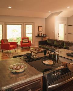 a kitchen with a stove top oven next to a living room at Perfect Luxe Retreat with Hot Tub in Gerton +6 photos