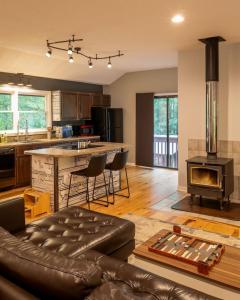 a kitchen and living room with a couch and a stove at Perfect Luxe Retreat with Hot Tub in Gerton