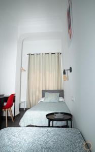 a bedroom with two beds and a table and a desk at FLATS FAMILY APARTAMENTO DE 3 HABITACIONEs in Valencia