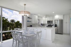 une cuisine avec des armoires blanches et une table et des chaises dans l'établissement Gorgeous Island Beach Club Condo BRAND NEW, à Sanibel