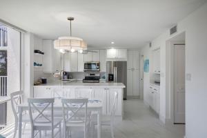une cuisine avec des armoires blanches et une table et des chaises dans l'établissement Gorgeous Island Beach Club Condo BRAND NEW, à Sanibel