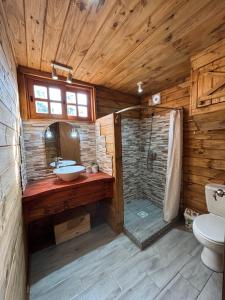 a bathroom with a shower and a sink and a toilet at Cabaña Luz de Luna en La Esmeralda Rocha in La Esmeralda 
