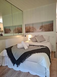 a bedroom with a large bed with two windows at Appartement neuf proche Nantes avec parking in Carquefou